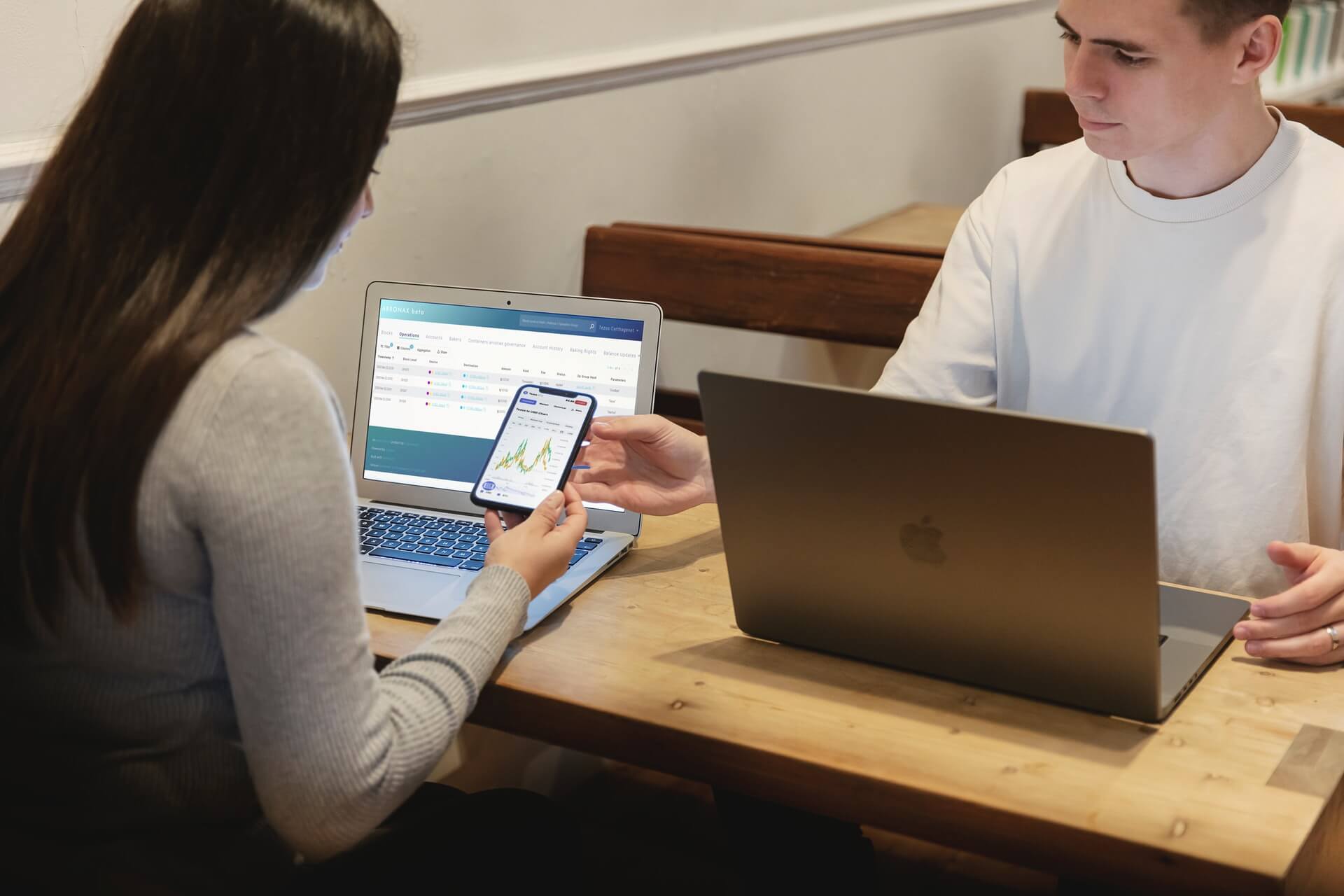 Jóvenes realizando operaciones financieras en sus dispositivos electrónicos.